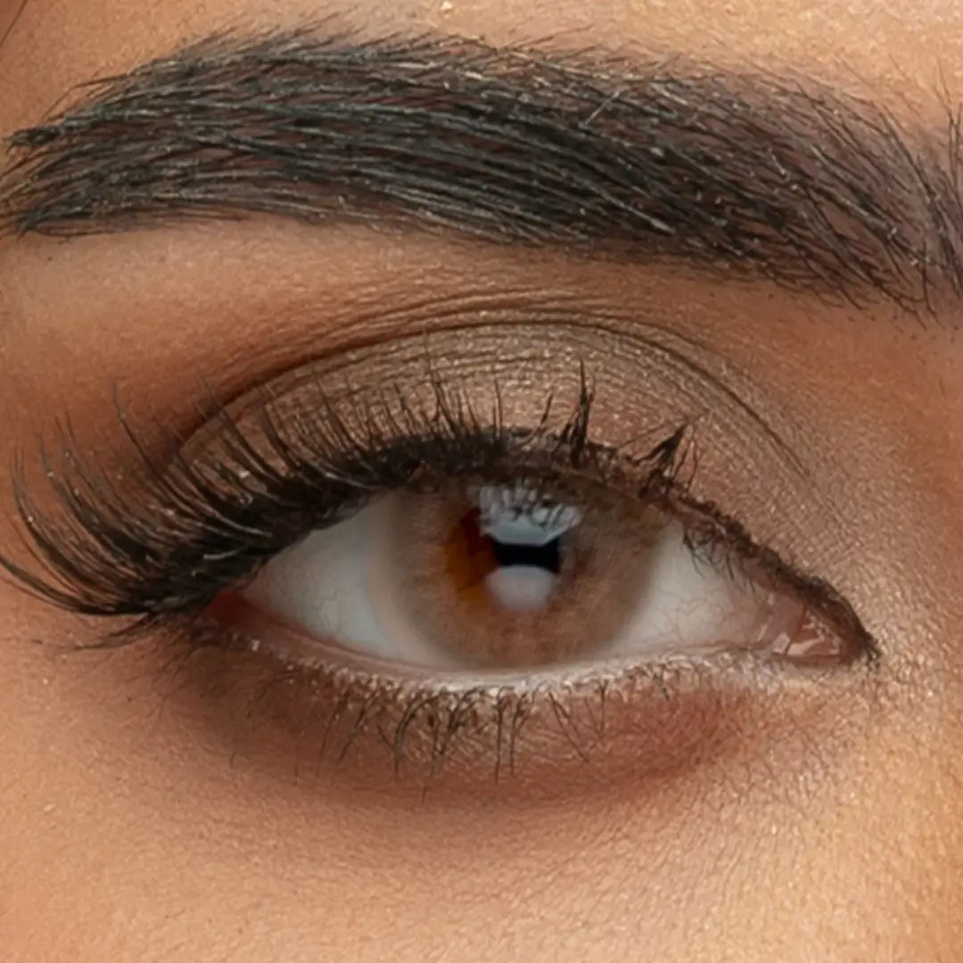 A detailed close-up of the Sama Monthly Lilium Hazel contact lens on a dark iris, showing the transition from honey-brown to soft green.