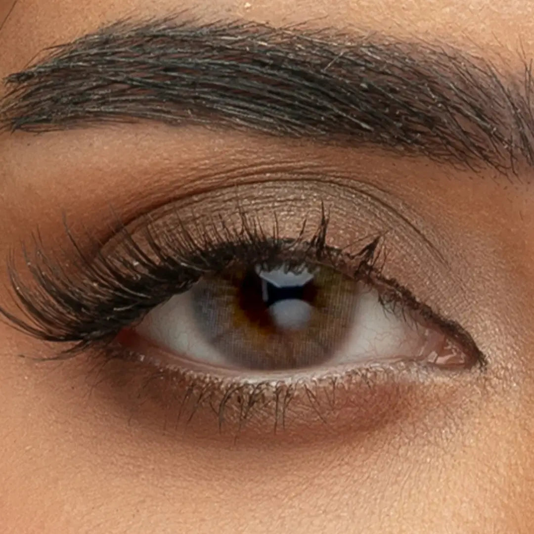 Close-up of a person wearing Sama Monthly Ruby contact lenses, showing the deep red-brown natural iris pattern and high-gloss finish.
